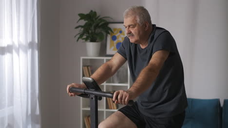 portrait-of-middle-aged-person-training-on-exercise-bike-at-home-keeping-fit-and-losing-weight-cardio-workout-for-health-and-good-feeling